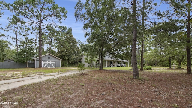 exterior space with a barn, a garage, fence, an outbuilding, and driveway