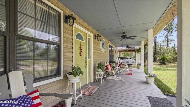 deck featuring covered porch, a lawn, and a ceiling fan