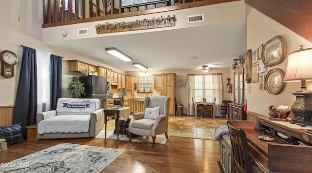 living room with a ceiling fan, light wood finished floors, and visible vents
