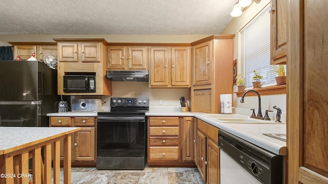 kitchen featuring black appliances, under cabinet range hood, a sink, light countertops, and a textured ceiling