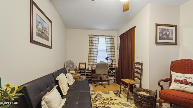 office space with light wood-style floors, a ceiling fan, and a textured ceiling