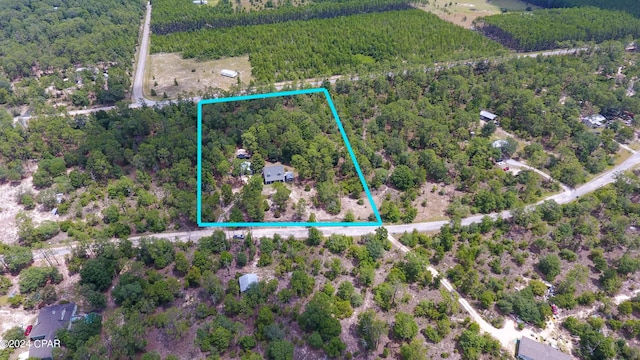 birds eye view of property featuring a view of trees
