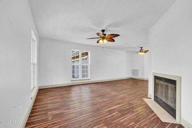 8508 S Holland Rd, Southport, FL 32409 - unfurnished living room featuring a fireplace with flush hearth, wood finished floors, a ceiling fan, heating unit, and baseboards
