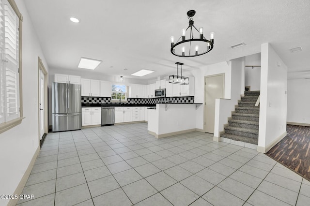 8508 S Holland Rd, Southport, FL 32409 - kitchen featuring appliances with stainless steel finishes, dark countertops, tasteful backsplash, open floor plan, and baseboards