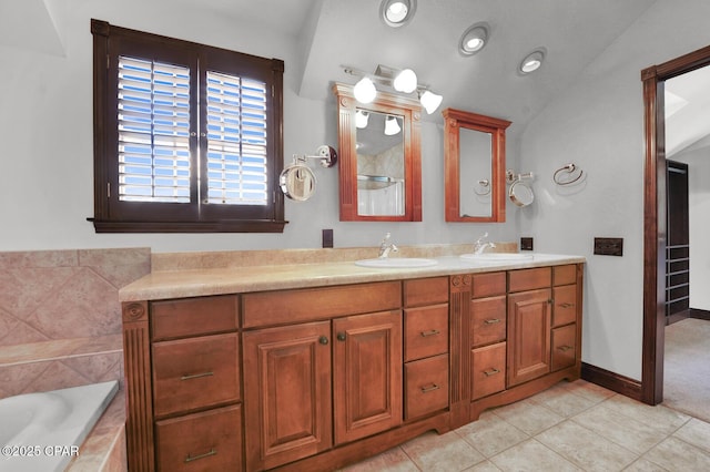 8508 S Holland Rd, Southport, FL 32409 - bathroom with double vanity, tile patterned flooring, tiled bath, lofted ceiling, and baseboards