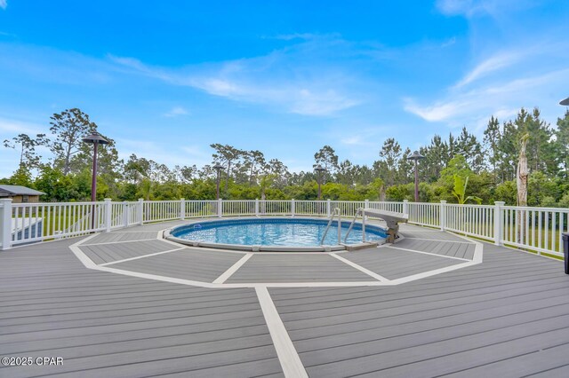 8508 S Holland Rd, Southport, FL 32409 - view of swimming pool featuring a wooden deck and view of scattered trees