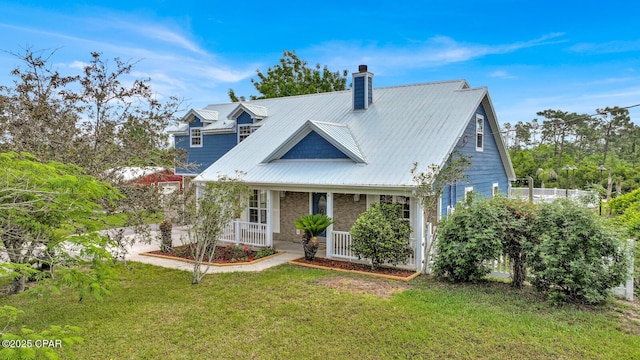 8508 S Holland Rd, Southport, FL 32409 - view of front of property featuring covered porch, a front yard, a chimney, and metal roof