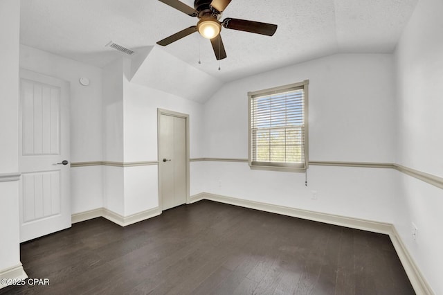 8508 S Holland Rd, Southport, FL 32409 - spare room with vaulted ceiling, dark wood-style flooring, ceiling fan, a textured ceiling, and baseboards