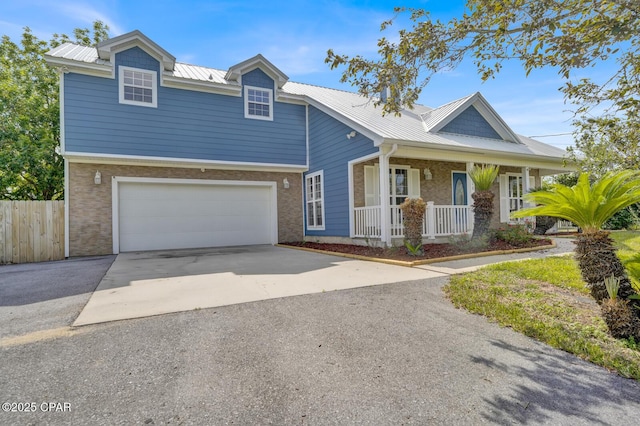8508 S Holland Rd, Southport, FL 32409 - traditional-style home featuring a porch, asphalt driveway, metal roof, an attached garage, and brick siding