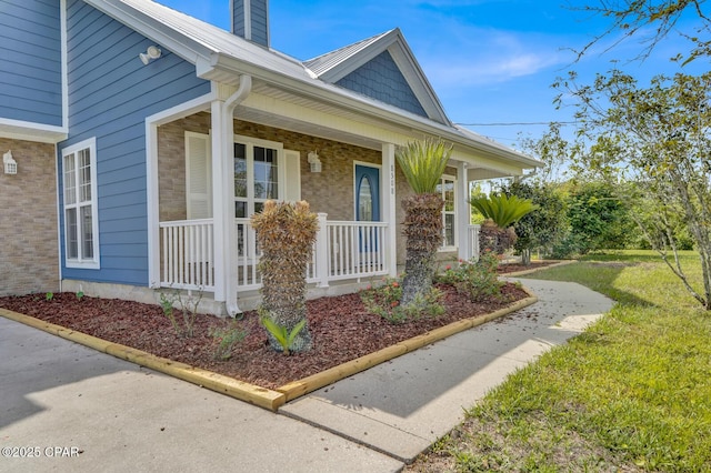 8508 S Holland Rd, Southport, FL 32409 - doorway to property with a porch, a chimney, and brick siding