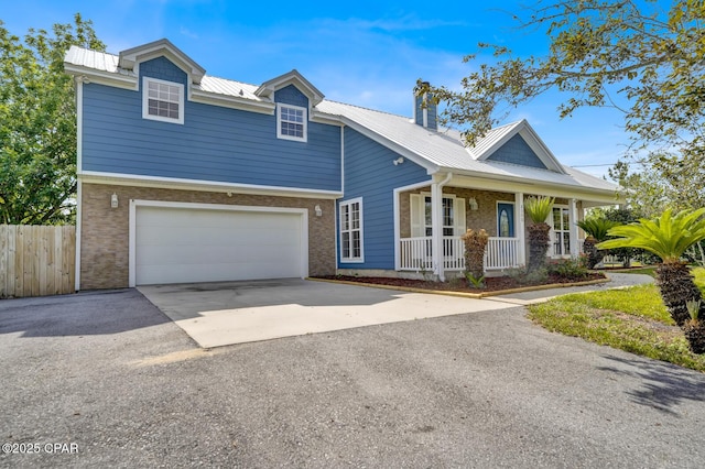 8508 S Holland Rd, Southport, FL 32409 - view of front of house featuring a porch, asphalt driveway, metal roof, a chimney, and brick siding