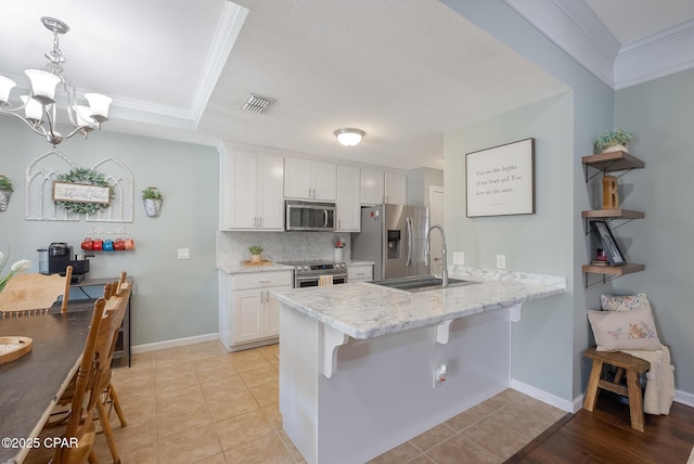 3543 Brentwood Pl, Panama City, FL 32404 - kitchen featuring stainless steel appliances, a sink, a peninsula, white cabinets, and crown molding