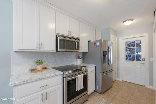 3543 Brentwood Pl, Panama City, FL 32404 - kitchen with appliances with stainless steel finishes, white cabinets, tasteful backsplash, light tile patterned floors, and light stone countertops