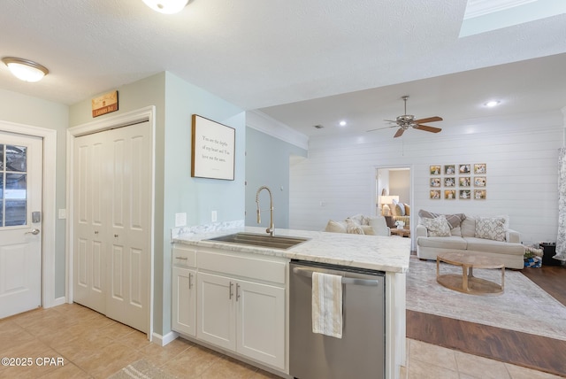 3543 Brentwood Pl, Panama City, FL 32404 - kitchen with stainless steel dishwasher, a sink, white cabinets, light tile patterned floors, and a peninsula