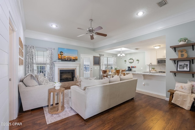 3543 Brentwood Pl, Panama City, FL 32404 - living room featuring crown molding, a ceiling fan, dark wood-style flooring, a glass covered fireplace, and recessed lighting