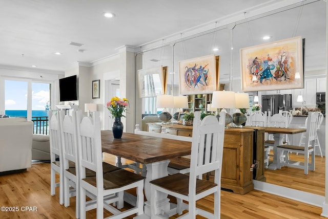 dining area featuring ornamental molding, light wood-style flooring, and recessed lighting