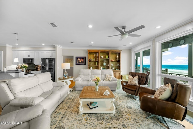 living room featuring crown molding, a ceiling fan, recessed lighting, and a water view