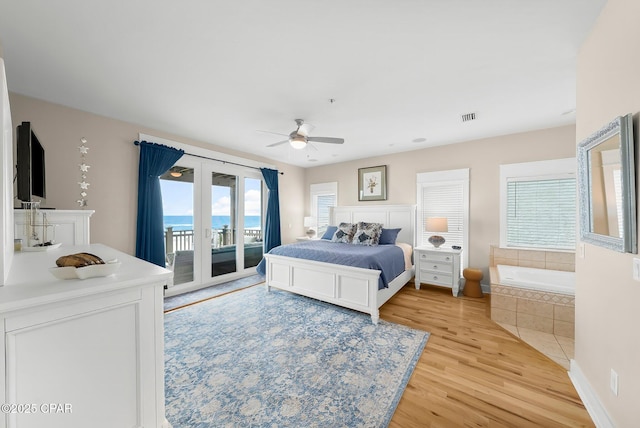 bedroom featuring access to exterior, light wood-style flooring, french doors, and ceiling fan