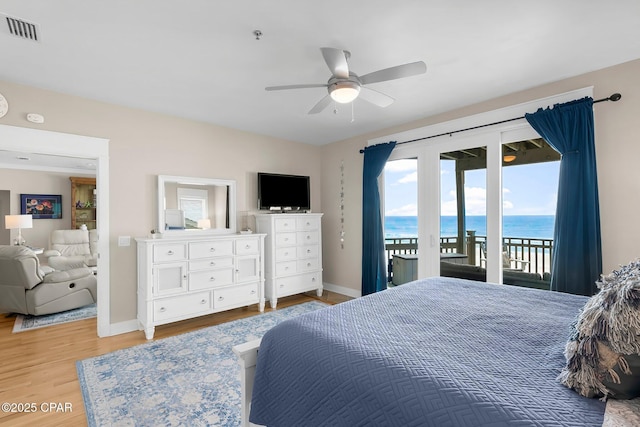 bedroom with access to outside, baseboards, wood finished floors, and a ceiling fan