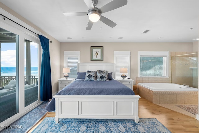 bedroom featuring access to exterior, light wood-style floors, and a ceiling fan