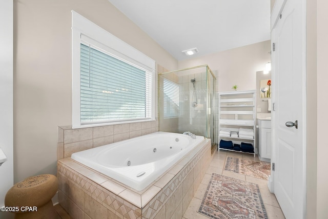 bathroom featuring a shower stall, a tub with jets, tile patterned floors, and vanity