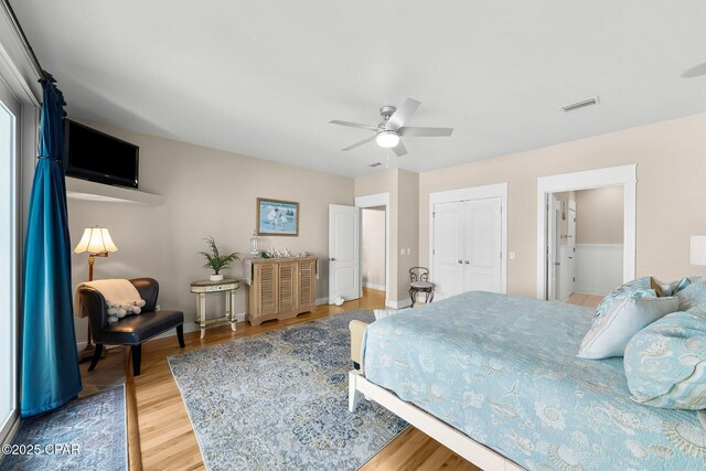 bedroom featuring wood finished floors, a closet, a ceiling fan, and baseboards