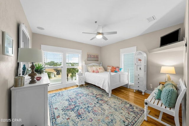 bedroom with wood finished floors, ceiling fan, and baseboards