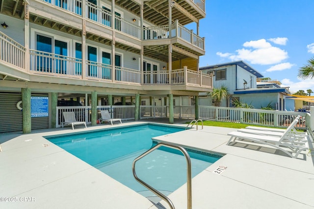 community pool with fence and a patio area