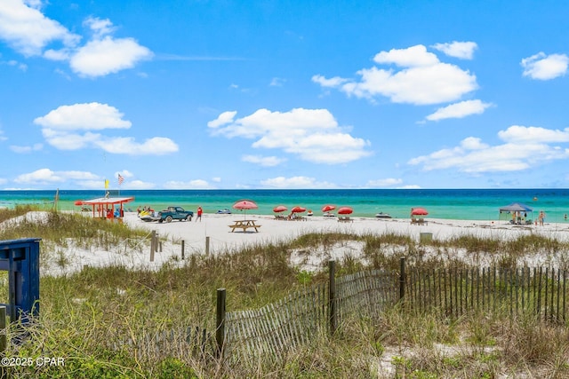 water view featuring local beach and fence