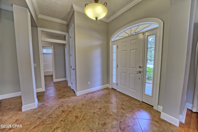 tiled foyer with crown molding and baseboards
