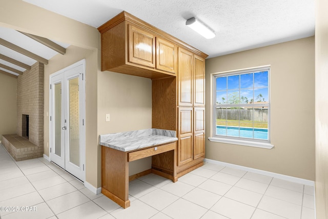 7936 Betty Louise Dr, Panama City, FL 32404 - mudroom featuring light tile patterned floors, baseboards, a fireplace, and built in desk