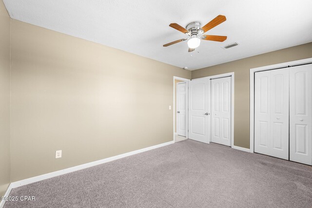7936 Betty Louise Dr, Panama City, FL 32404 - unfurnished bedroom with carpet floors, multiple closets, baseboards, and ceiling fan