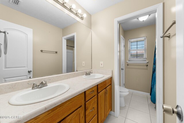 7936 Betty Louise Dr, Panama City, FL 32404 - bathroom with tile patterned floors, double vanity, toilet, and baseboards
