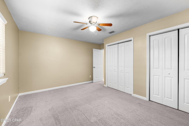 7936 Betty Louise Dr, Panama City, FL 32404 - unfurnished bedroom featuring two closets, carpet, baseboards, and a textured ceiling