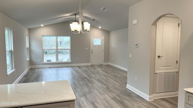 11438 Palm Breeze St, Panama City, FL 32404 - foyer entrance featuring a chandelier, light wood-type flooring, arched walkways, lofted ceiling, and baseboards
