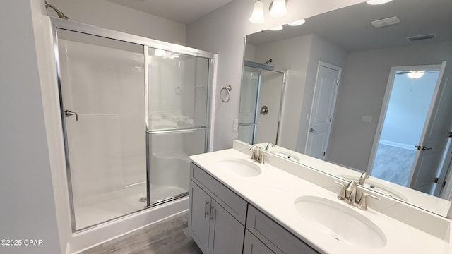 11442 Palm Breeze St, Panama City, FL 32404 - bathroom with a stall shower, double vanity, and wood finished floors