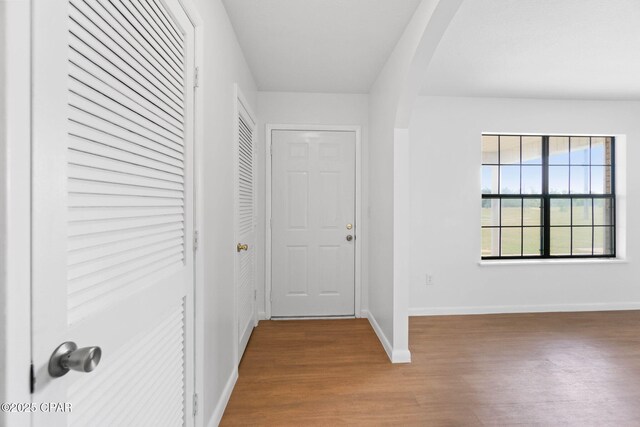 10367 NW County Road 274, Altha, FL 32421 - hallway featuring arched walkways, wood finished floors, and baseboards