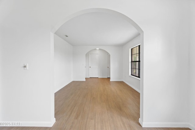 10367 NW County Road 274, Altha, FL 32421 - corridor featuring baseboards, light wood-style flooring, and arched walkways