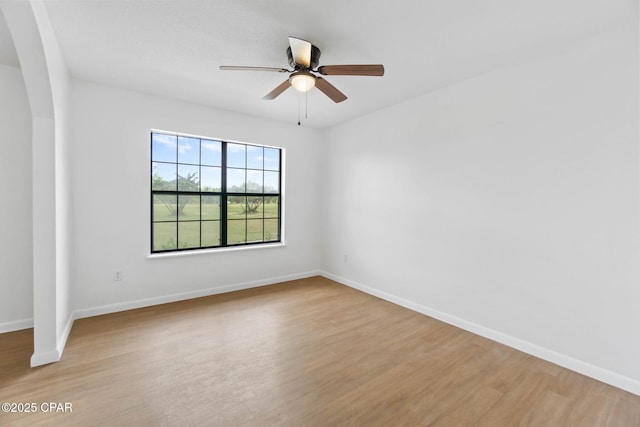 10367 NW County Road 274, Altha, FL 32421 - spare room featuring arched walkways, light wood-style floors, a ceiling fan, and baseboards