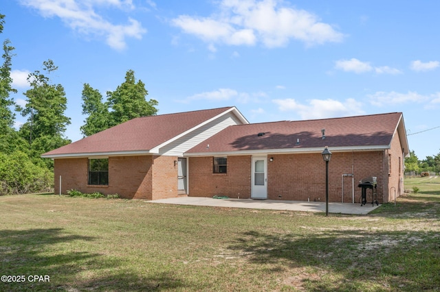 10367 NW County Road 274, Altha, FL 32421 - rear view of house featuring a patio area, a yard, brick siding, and a shingled roof