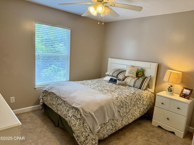 bedroom featuring light colored carpet, multiple windows, ceiling fan, and baseboards