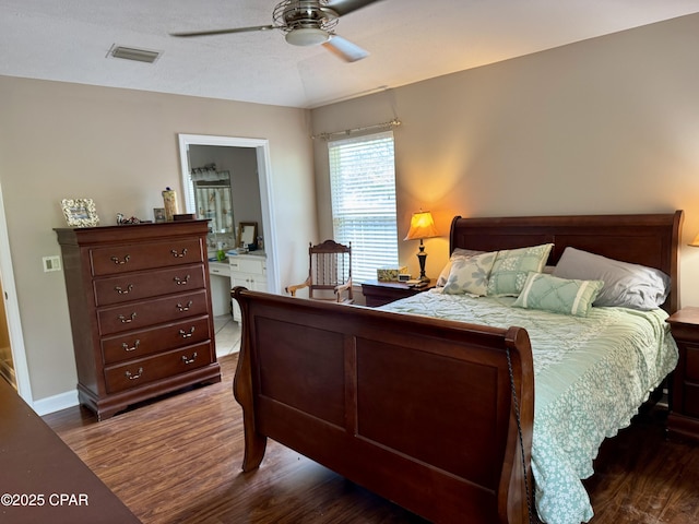 bedroom with dark wood finished floors, ceiling fan, and connected bathroom