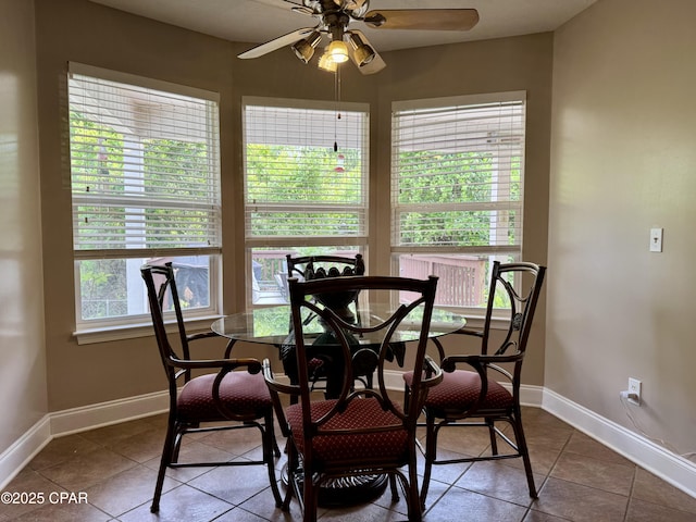 dining area with a ceiling fan, baseboards, and tile patterned flooring