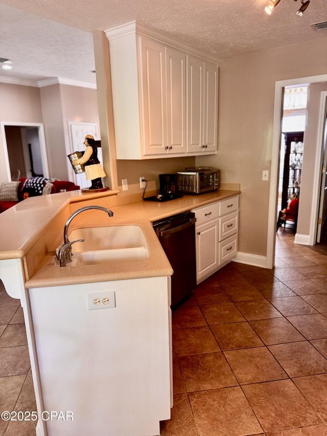 kitchen featuring dishwashing machine, a sink, a textured ceiling, light countertops, and white cabinets