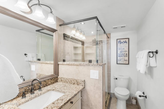 bathroom featuring a stall shower, vanity, toilet, and tile patterned flooring