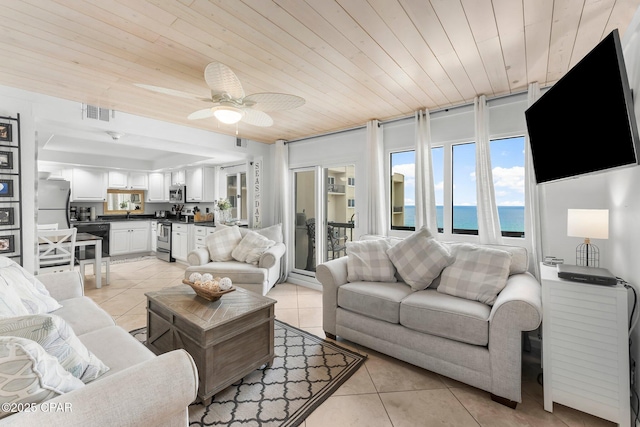 living area with light tile patterned flooring, a ceiling fan, and wooden ceiling
