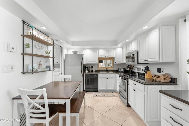 kitchen with stainless steel appliances, a sink, white cabinets, light tile patterned floors, and recessed lighting