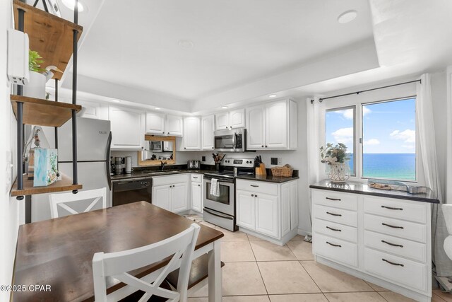 kitchen featuring appliances with stainless steel finishes, dark countertops, white cabinetry, recessed lighting, and light tile patterned floors