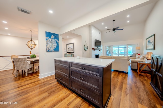 kitchen with a ceiling fan, a large fireplace, recessed lighting, light countertops, and light wood-style flooring