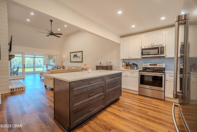kitchen featuring stainless steel appliances, white cabinets, light countertops, light wood-style floors, and ceiling fan
